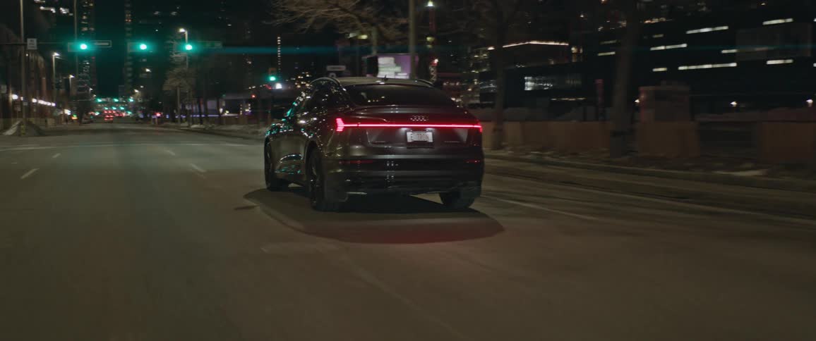 A car driving down a road in a city at night