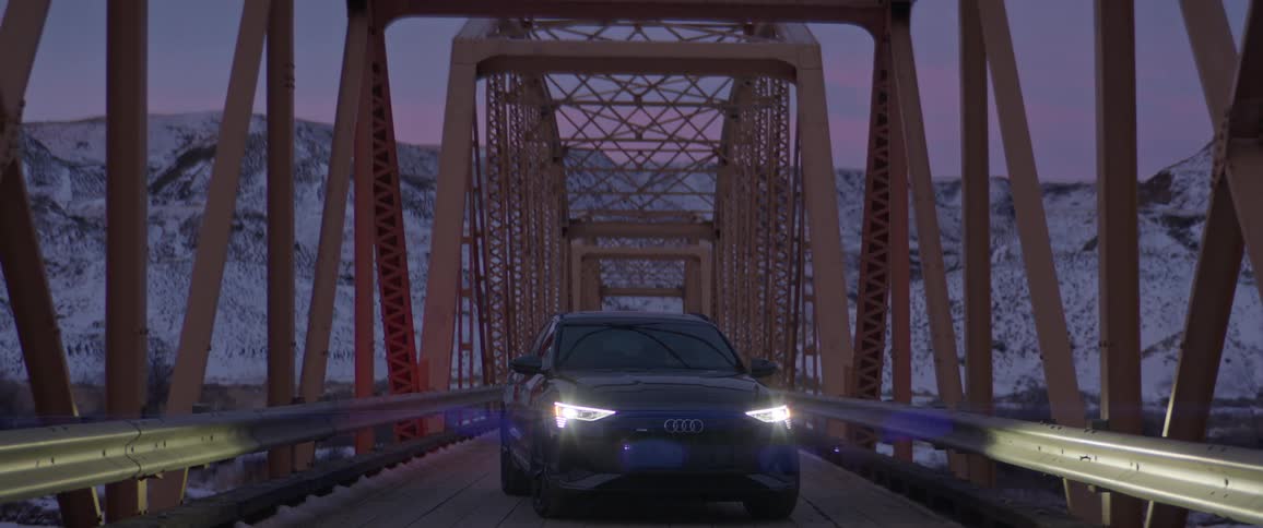 A view of a car on a bridge in the winter