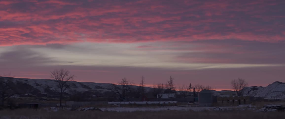 Snow covered mountains under a colorful pink and purple sky