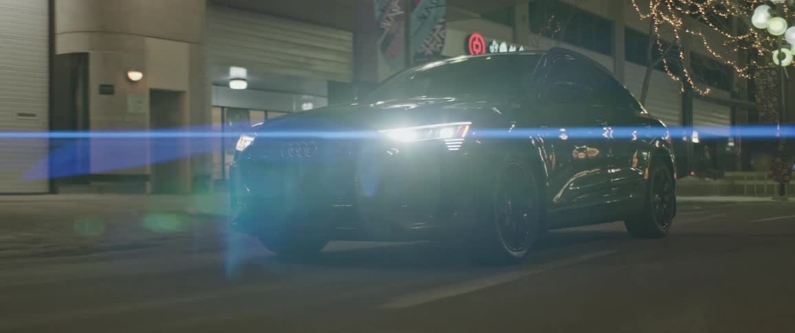 A vehicle travels down a city road at night