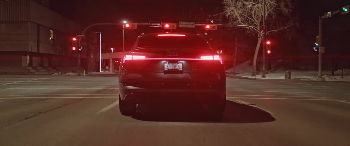 Black car parked on an intersection in the city at night