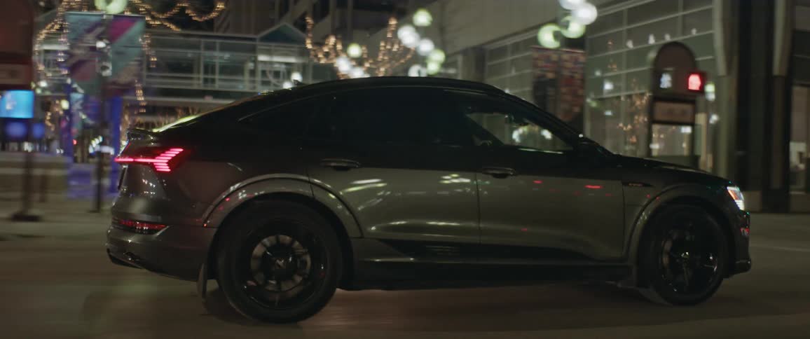 A vehicle drives a large city road at night