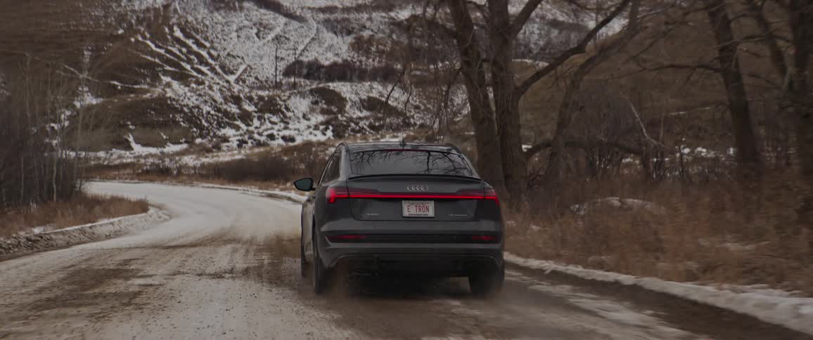 A car is driving in a rural area during winter