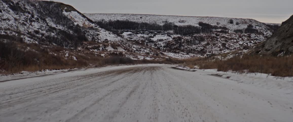 Snow covered rural dirt road in the countryside at evening