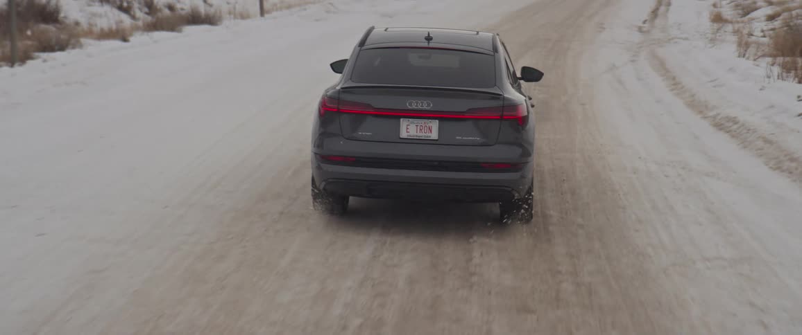 A vehicle drives along a snow covered road