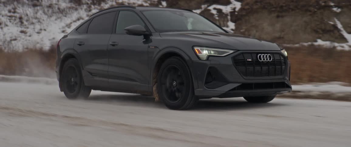 A vehicle drives on a snow dusted rural road