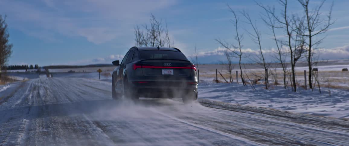 A car is driving in a rural area in winter