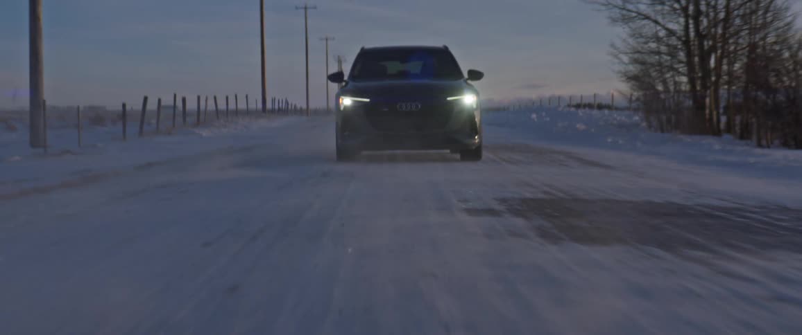 A view of a car driving down a snowy road