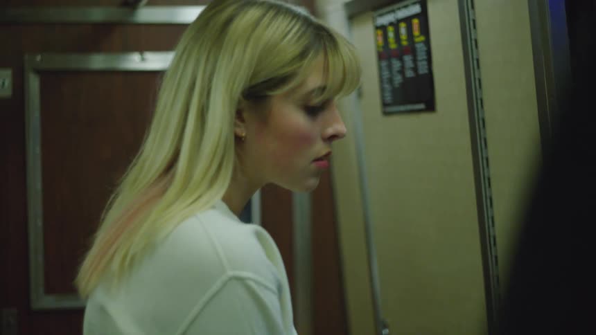 A woman is standing on the train as it moves