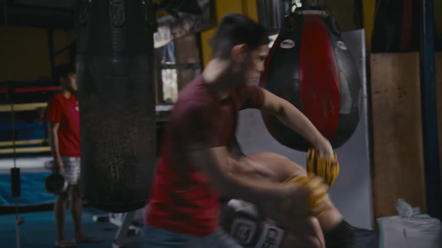 Two men are boxing indoors in a boxing ring