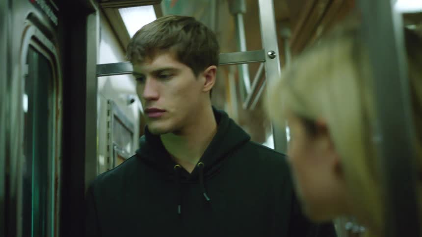A man and a woman standing on a moving train