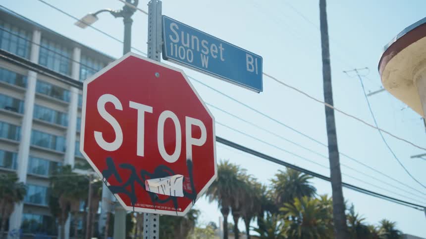 A stop sign outside an apartment building is marked with graffiti