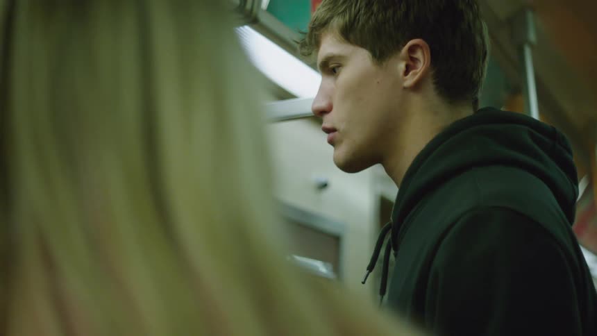 A man and a woman standing on a train