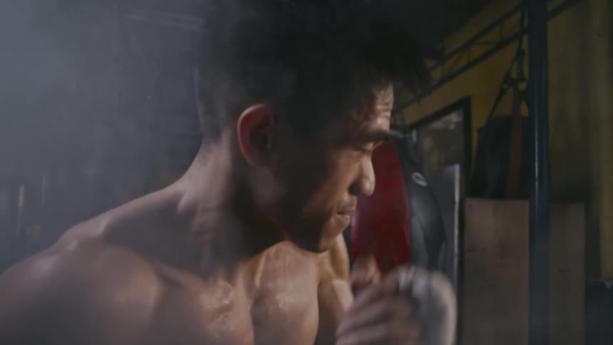 Young muscular shirtless man shadow boxing in front of the camera