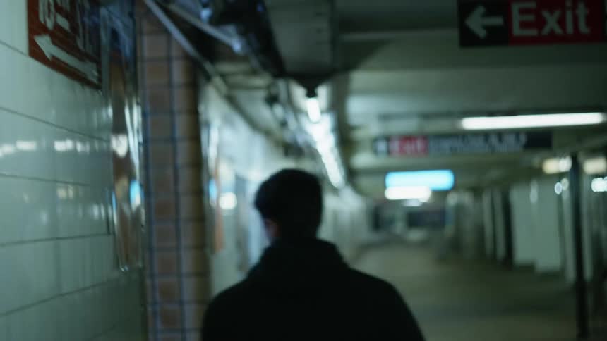 Young man walking on the corridor of a subway terminal to leave