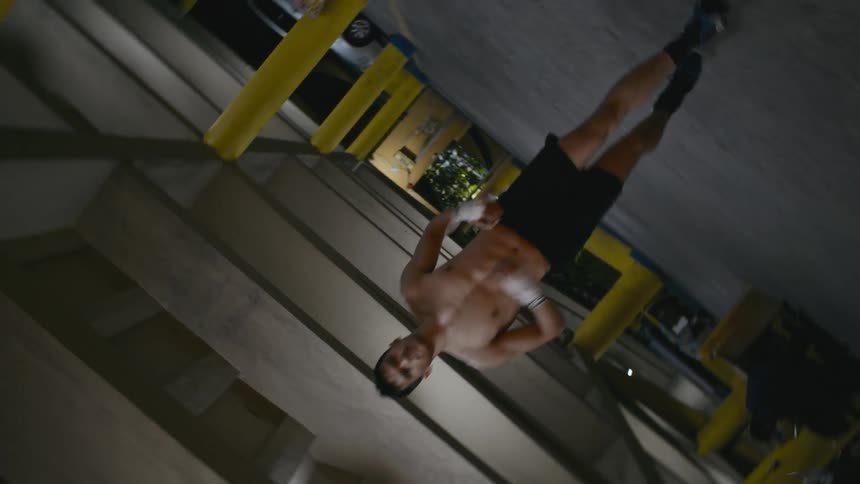 A muscular man jogs through a parking structure while throwing occasional punches at the air