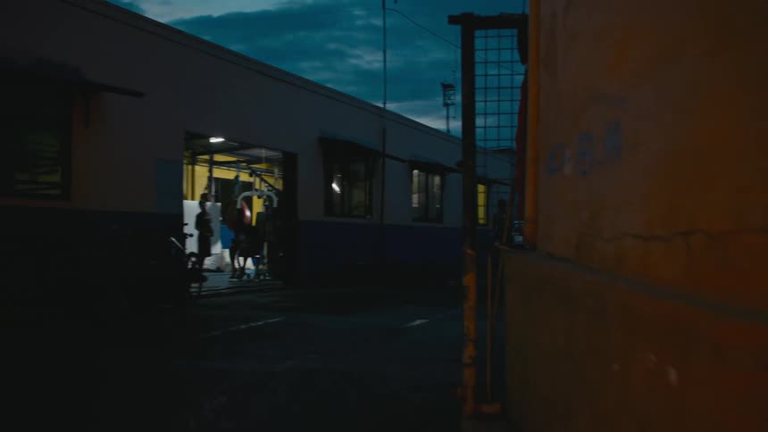 Young strong muscular man running on the streets of a small town at morning