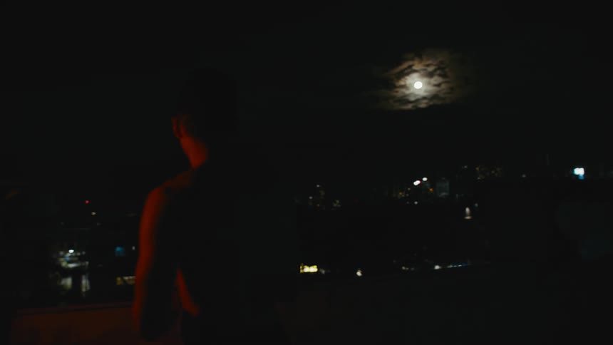 A man is standing outdoors at night