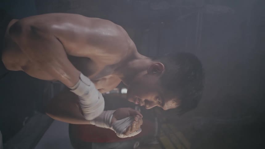 A man is shadow boxing in the foggy gym