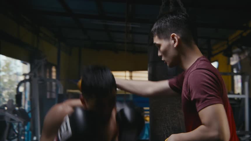 Boxer practicing with his sparring partner in the gym