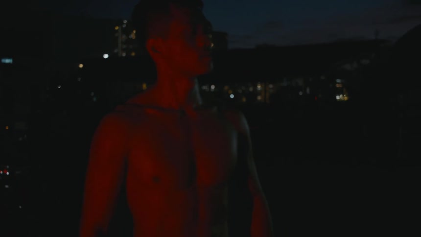 A shirtless asian man is posing and looking at a distance