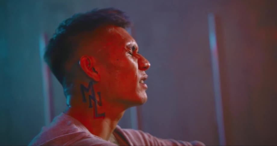 A man in a room singing with a wall in the background