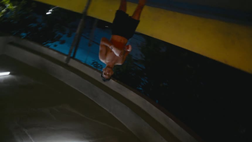 Young muscular shirtless man jogging on the ramp of a parking garage