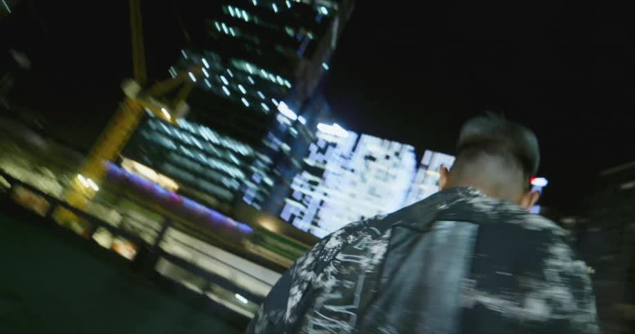 A man is dancing outdoors at night in the middle of the city