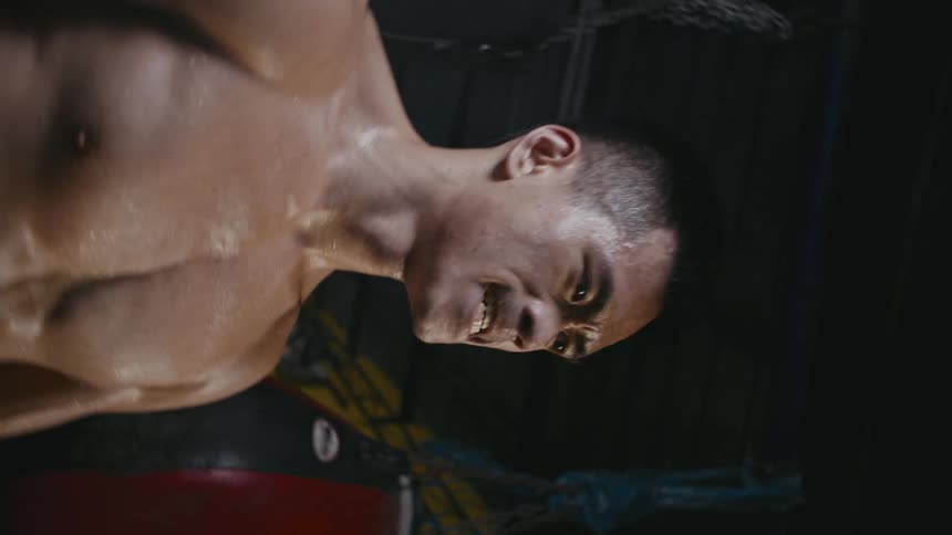 A man is in a gym and is working out aggressively