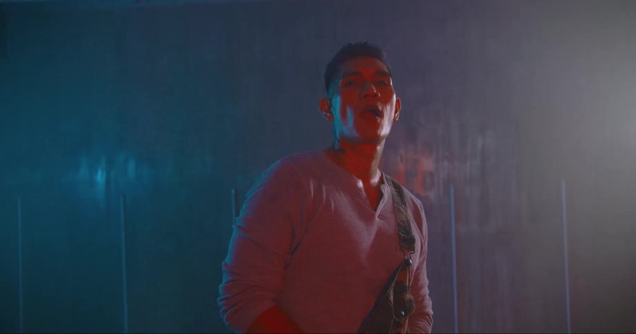 A man in a room standing with a wall in the background
