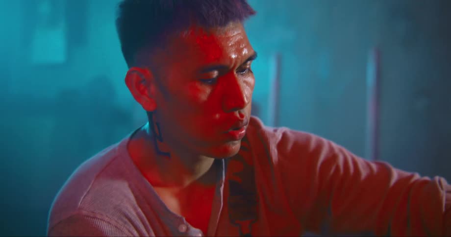 A man is sitting indoors and sweating