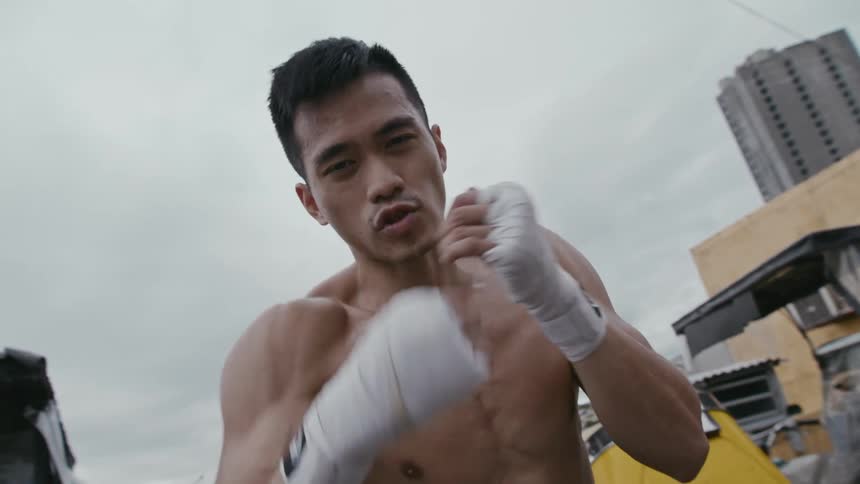 Young muscular shirtless man shadow boxing in front of the camera