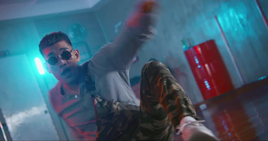 Young asian man dancing inside a room surrounded with colorful neon lights
