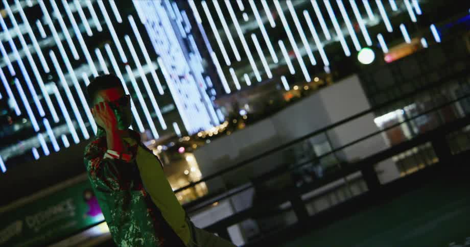 A man is dancing outdoors in a city at night