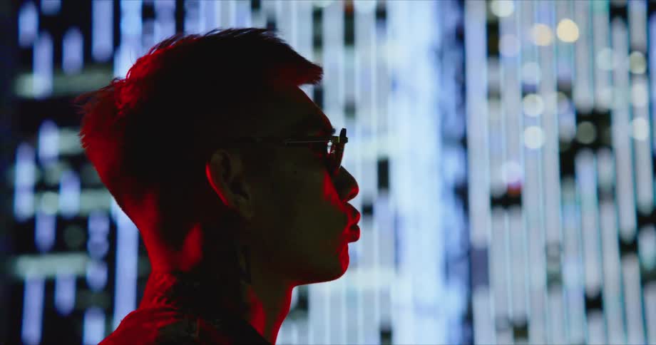 A man standing in a room staring at screens