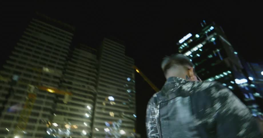 A man dances in the middle of the city at night