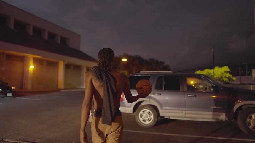 A man tosses a basketball as they get to the car