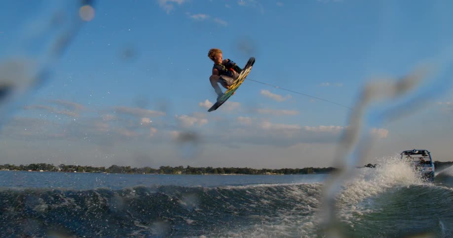 A man makes a huge jump on his board in the water