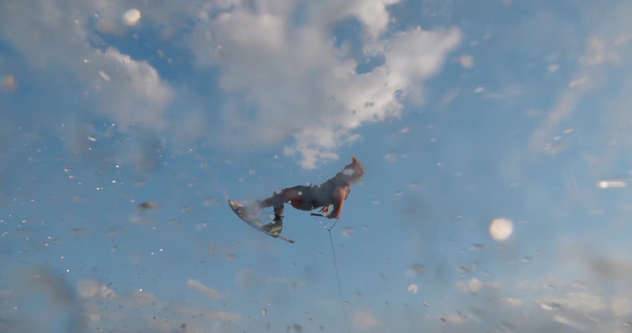 A man on a lake wake boarding with the sky and clouds in the background