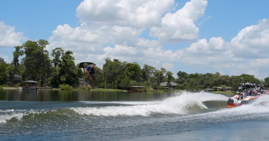 Water skier jumping over a wave on a lake at daytime