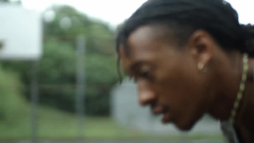 Young man crouched on a court dribbling basketballs with both hands