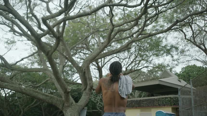 A man throws and catches a basketball walking in a park