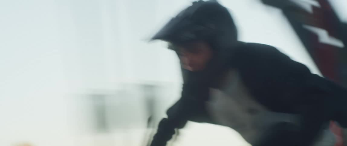 A man riding a motorcycle onto a bridge