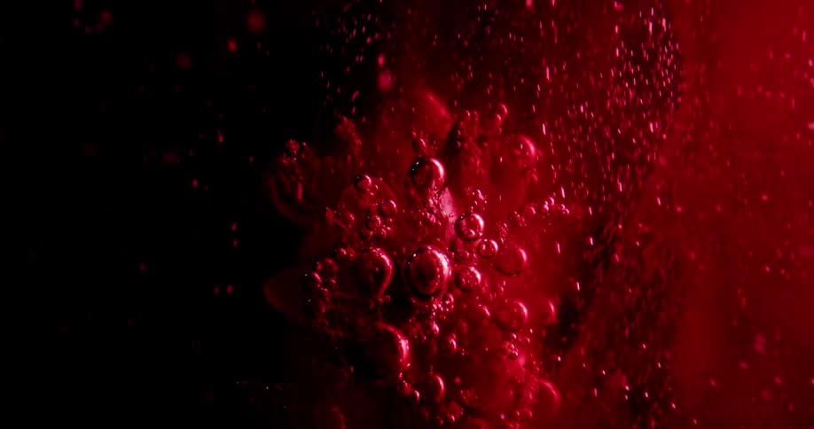 Red colored liquid is sprayed on a plant as water bubbles are going up