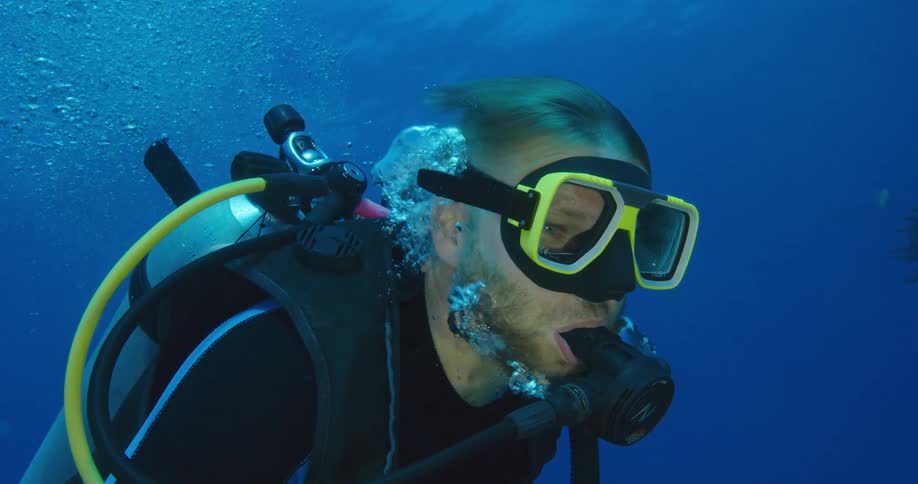 A man breathes underwater with a scuba tank