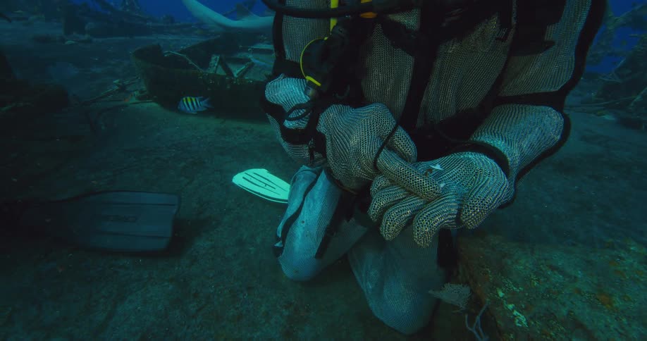 A diver is holding shark teeth in his hand