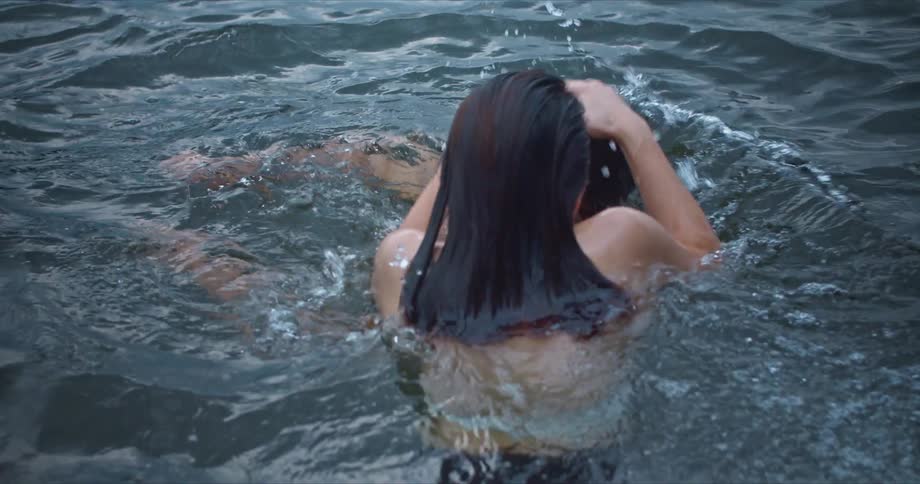 Young happy couple swimming in a lake playing with each other