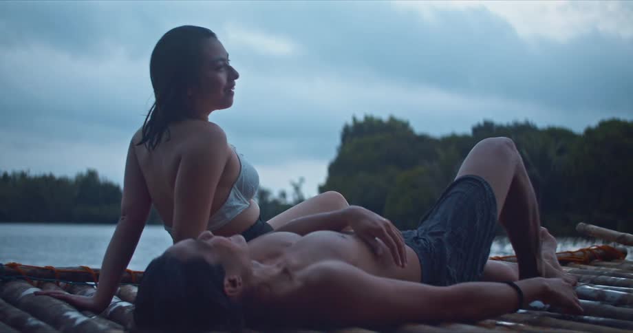 A man and woman laying around relaxing on a dock
