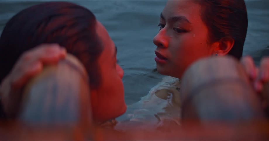 Two young woman look at each other as rest of their body is still underwater