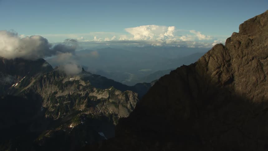 Snow covered mountains with peaks high in the clouds